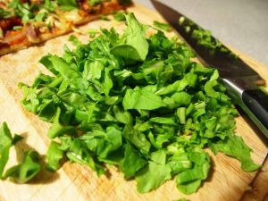 chopped arugula on a cutting board