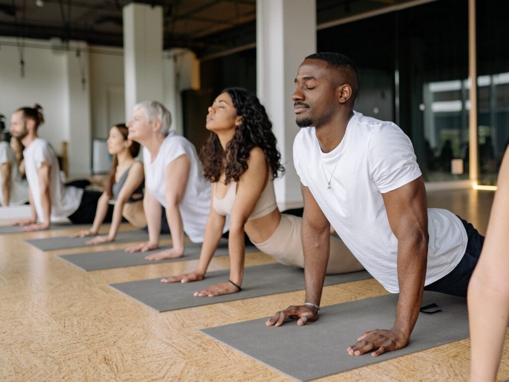 A group of people practicing yoga on mats in a studio