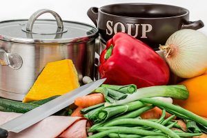 various vegetables next to two cooking pots